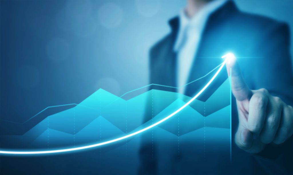 A person touches a glowing rising line graph, symbolizing business growth and success.