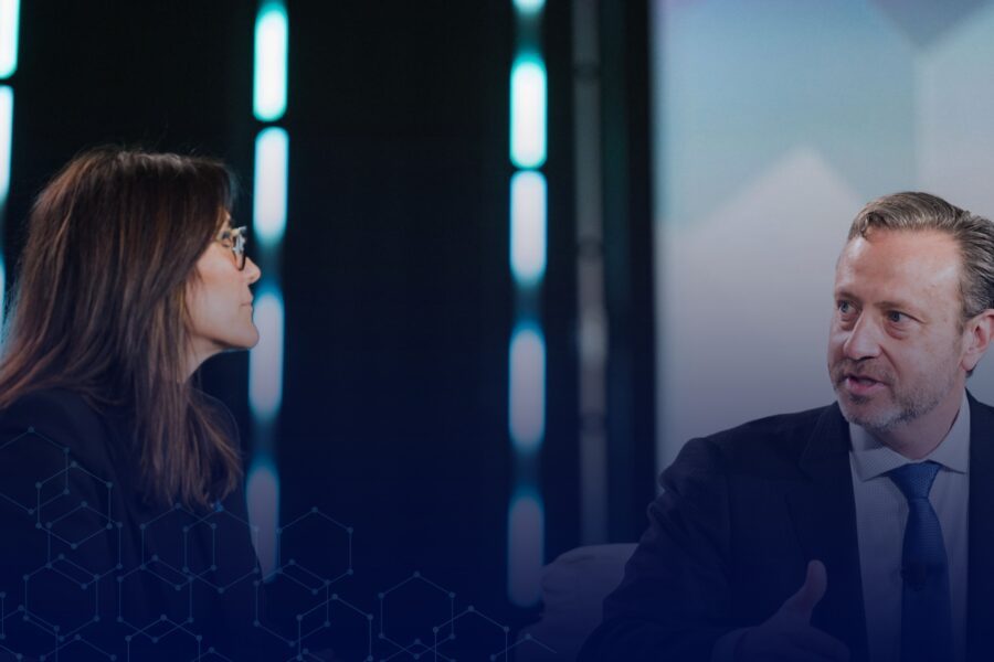 Two professionals discussing AI technology on a conference stage